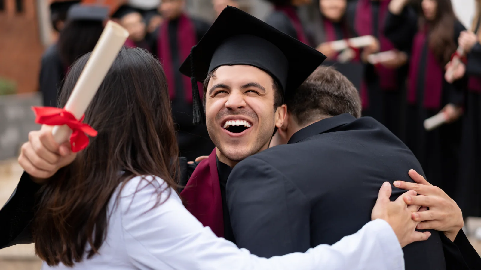 A graduate celebrating with friends at commencement