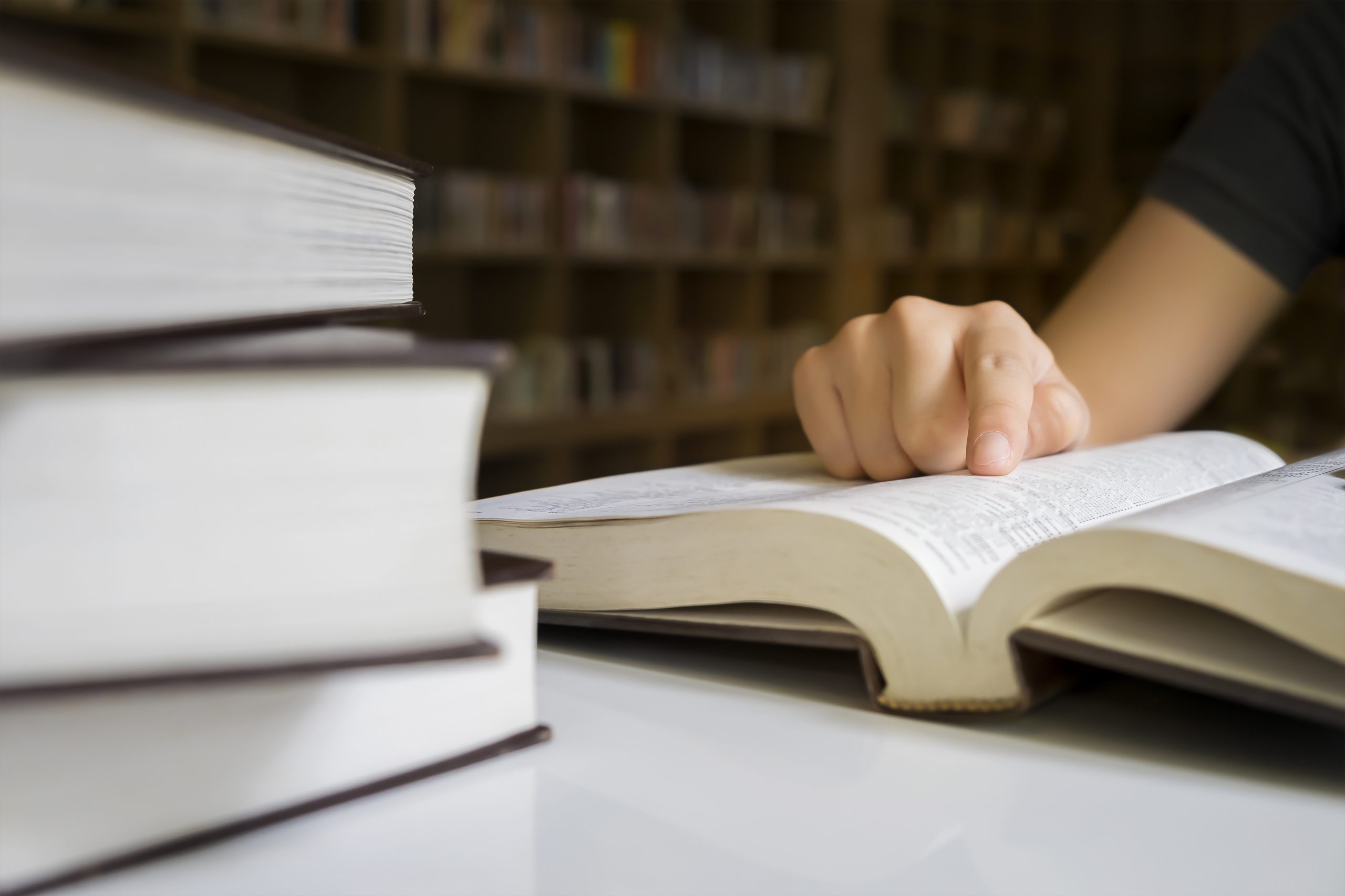 A law school applicant studying an open book in a library